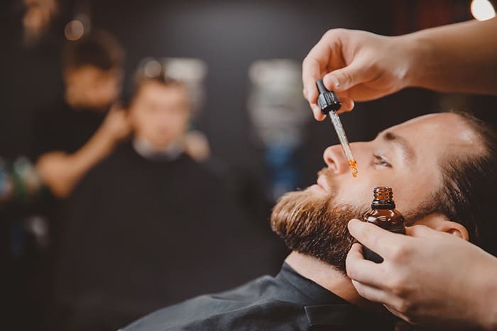 barber applies beard oil