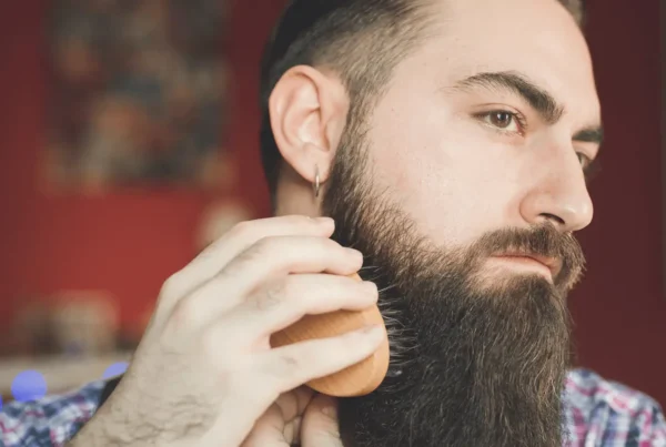 man brushes his beard with comb